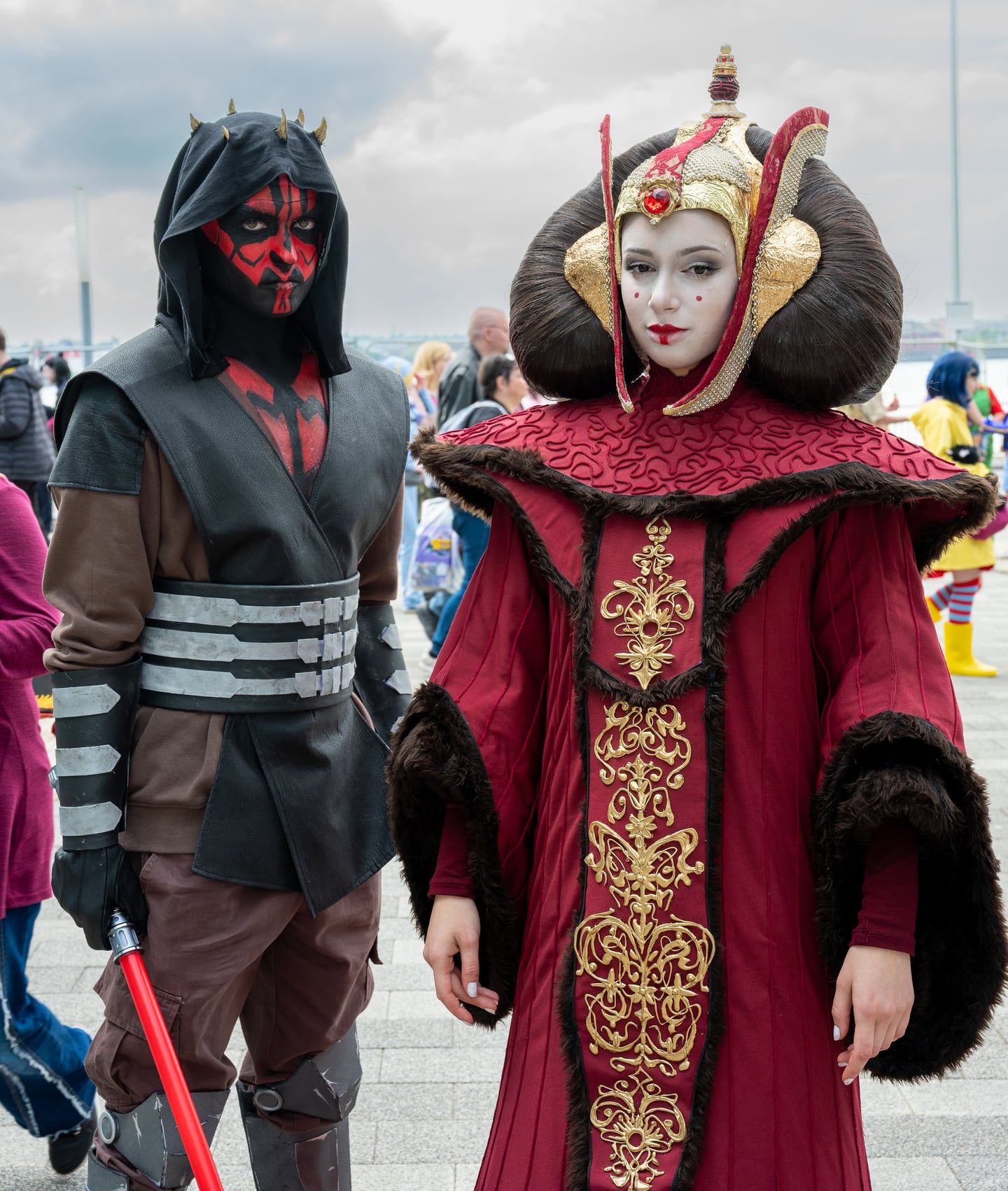 Two convention attendees in elaborate dark and red costumes.