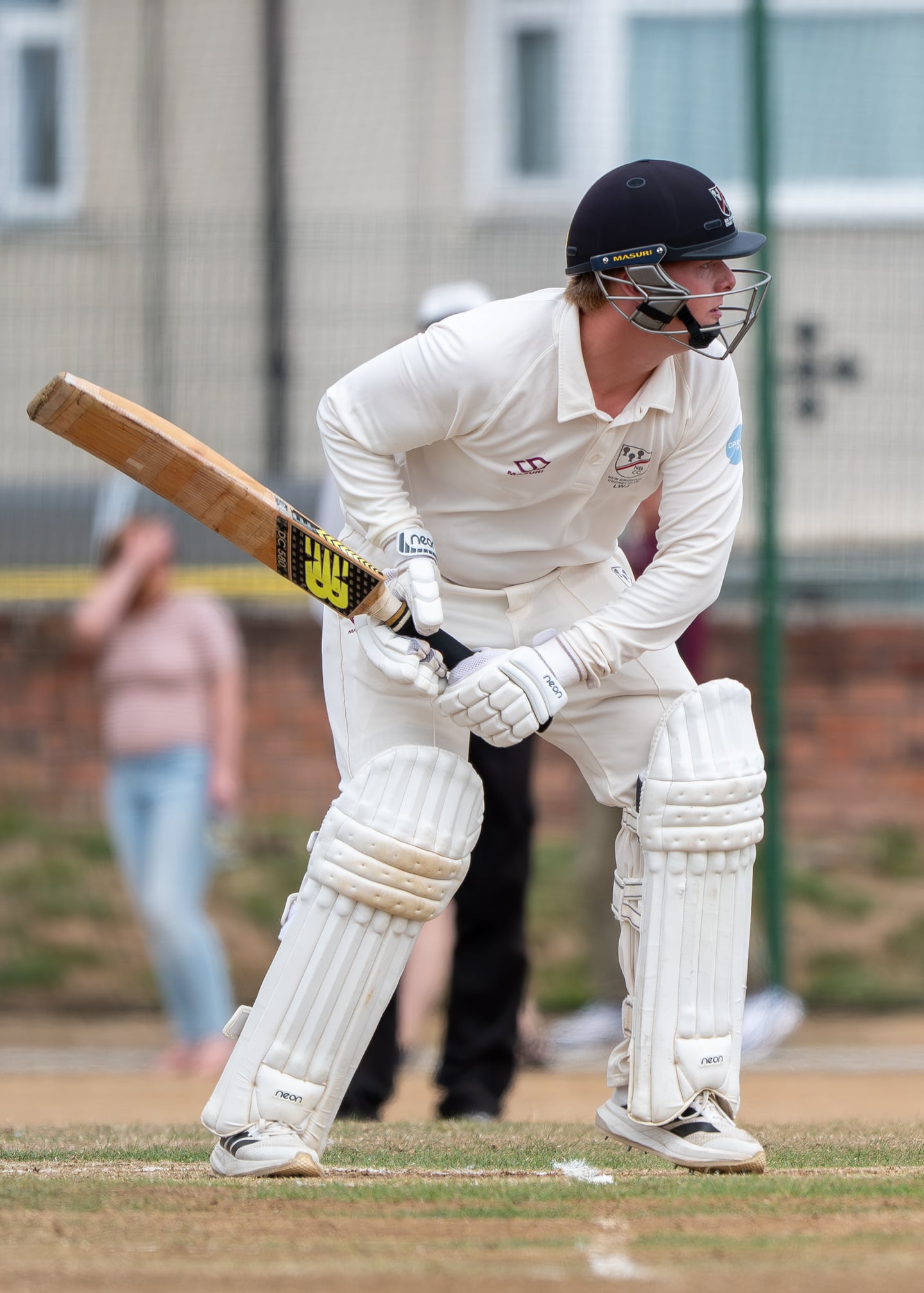 A cricket batter in a black helmet preparing to play a shot.
