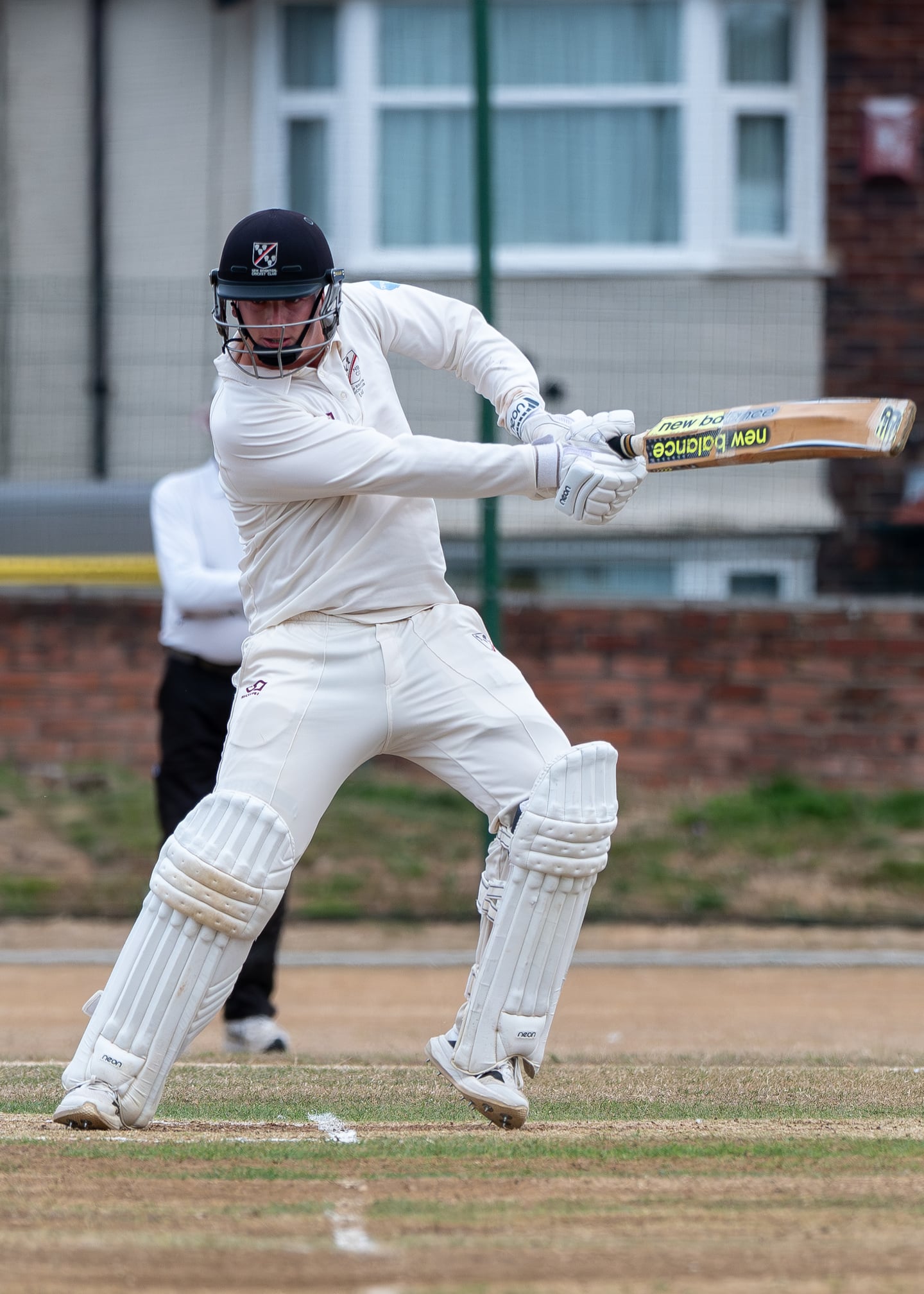 A cricket batter playing a forceful shot across the crease.