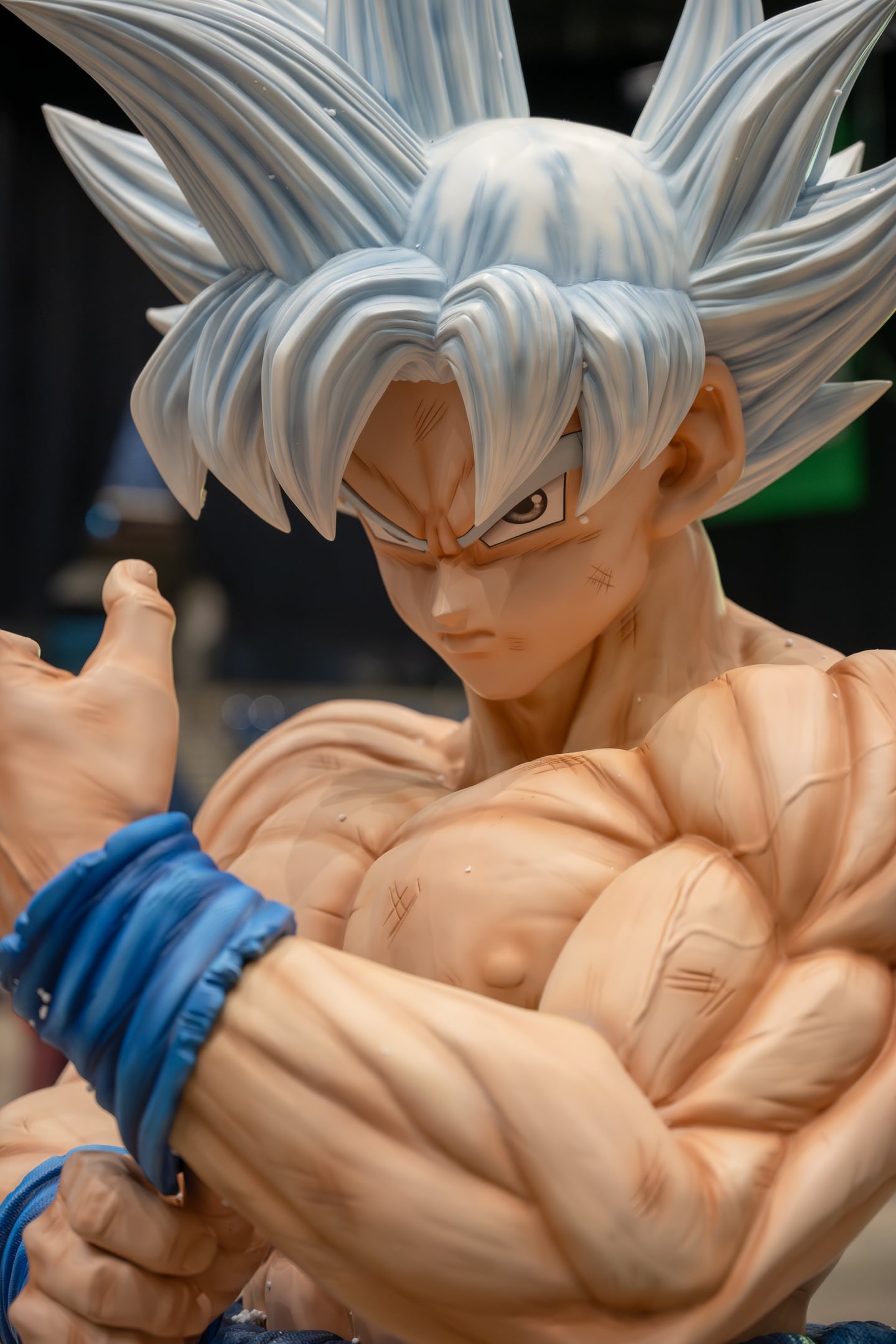 Close-up of a muscular, silver-haired character display at a convention.