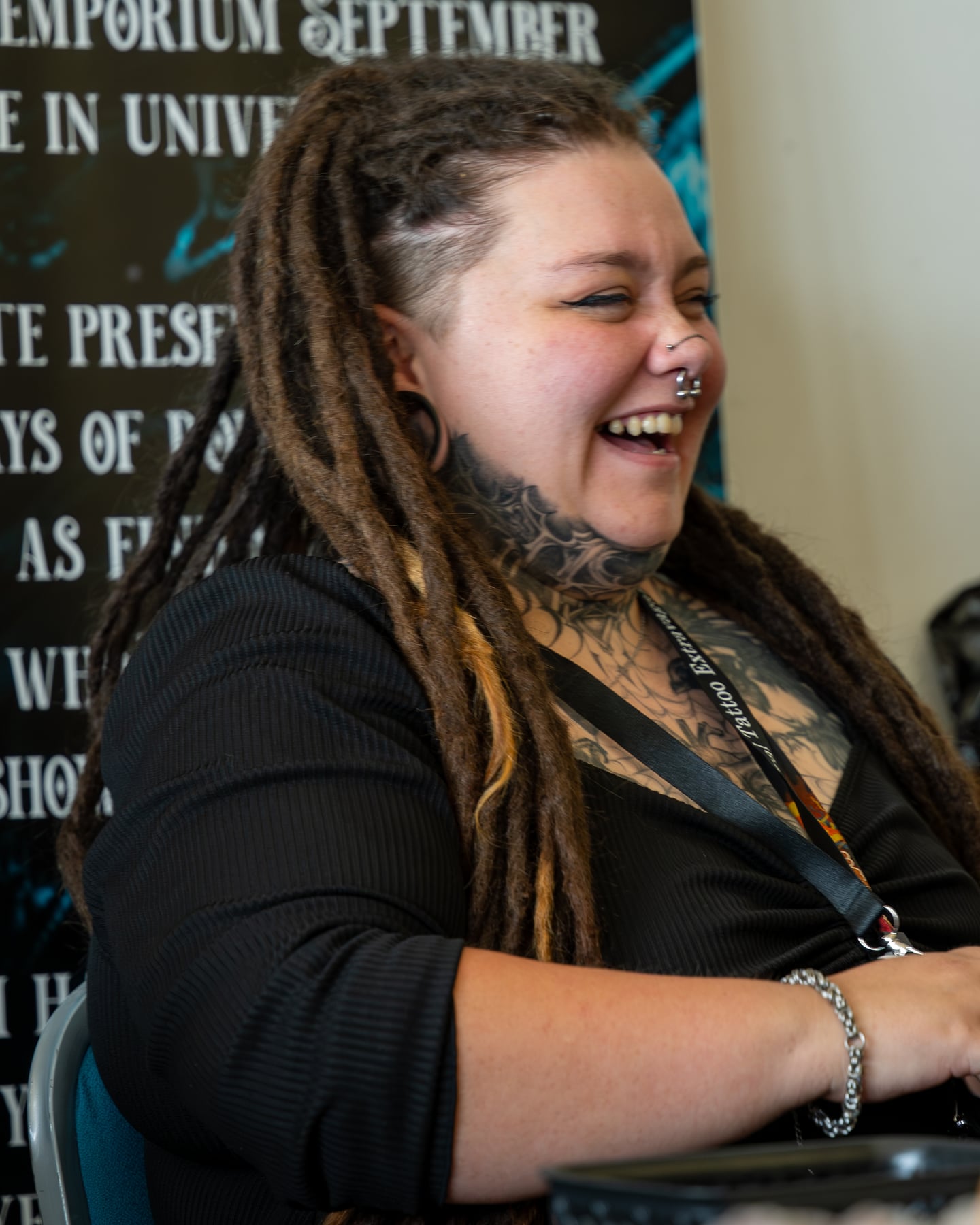 A tattoo artist laughing at a workstation during the event.